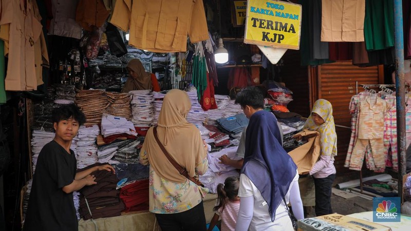 Sejumlah pembeli mencoba seragam dan atribut sekolah di kawasan Jatinegara, Jakarta Timur, Rabu (5/7/2023). (CNBC Indonesia/Faisal Rahman)