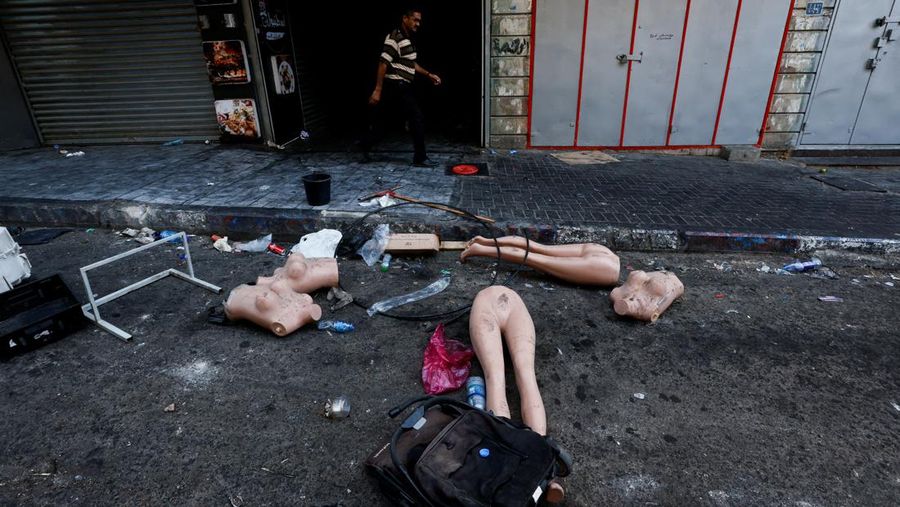 Seorang wanita Palestina duduk di depan sebuah bangunan yang rusak setelah penarikan tentara Israel dari kamp Jenin, di Jenin, di Tepi Barat yang diduduki Israel 5 Juli 2023. (REUTERS/Mohamad Torokman)