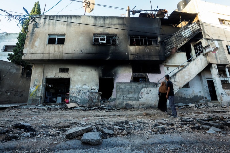 Seorang wanita Palestina duduk di depan sebuah bangunan yang rusak setelah penarikan tentara Israel dari kamp Jenin, di Jenin, di Tepi Barat yang diduduki Israel 5 Juli 2023. Seorang wanita Palestina duduk di depan sebuah bangunan yang rusak setelah penarikan tentara Israel dari kamp Jenin, di Jenin, di Tepi Barat yang diduduki Israel 5 Juli 2023. (REUTERS/Mohamad Torokman)