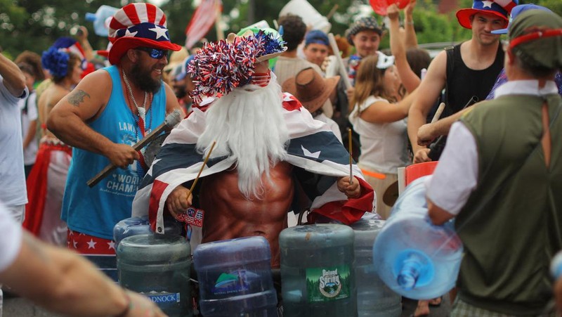 Masyarakat Amerika Serikat (AS) merayakan parade Fourth of July dengan membawa bendera di Westmont, Suburb of Johnstown, Selasa (4/7/2023). (REUTERS/BRIAN SNYDER)