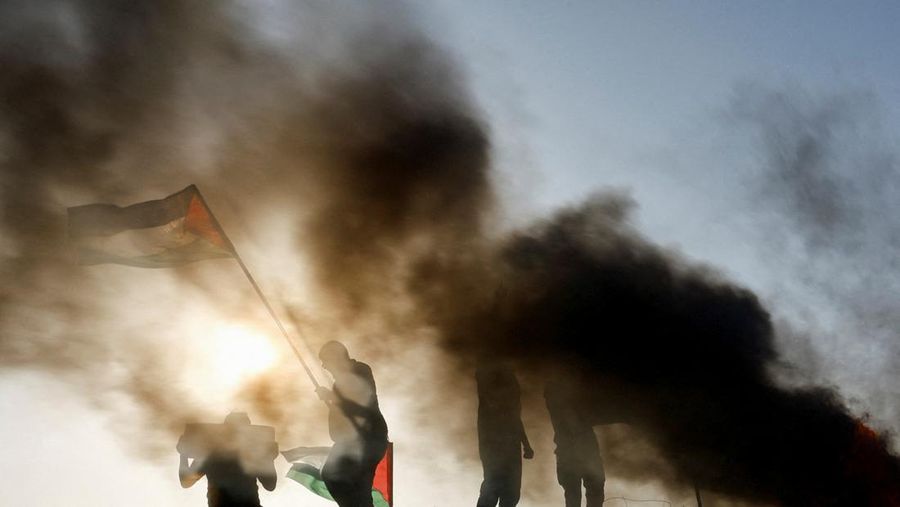 Warga Palestina memprotes serangan tentara Israel di Jenin, di sepanjang pagar perbatasan Israel-Gaza, di Khan Younis, di Jalur Gaza selatan, 4 Juli. (REUTERS/IBRAHEEM ABU MUSTAFA)