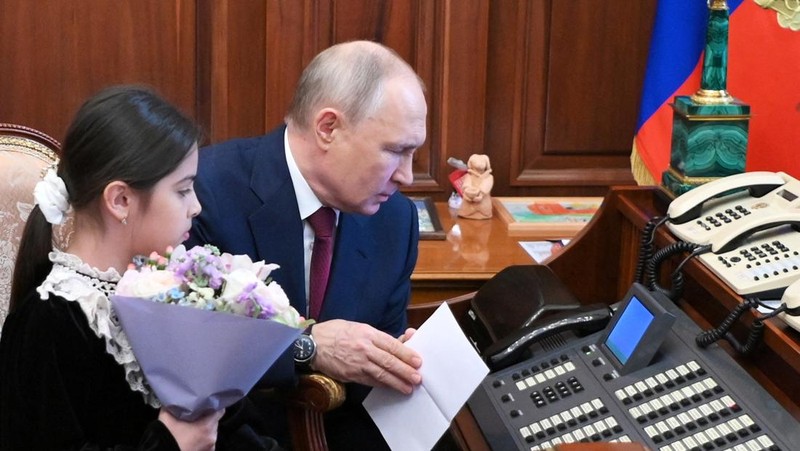 Raisat Akimova, seorang gadis berusia 8 tahun dari Derbent, dan orang tuanya Akhmet dan Kultum Aipovs menghadiri pertemuan dengan Presiden Rusia Vladimir Putin di Kremlin di Moskow, Rusia 4 Juli 2023. Raisat gagal menemui kepala negara selama kunjungannya perjalanan kerja ke Republik Dagestan di mana dia juga berbicara dengan penduduk setempat. (Sputnik/Alexander Kazakov/Kremlin via REUTERS)