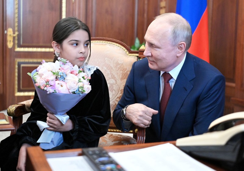 Raisat Akimova, seorang gadis berusia 8 tahun dari Derbent, dan orang tuanya Akhmet dan Kultum Aipovs menghadiri pertemuan dengan Presiden Rusia Vladimir Putin di Kremlin di Moskow, Rusia 4 Juli 2023. Raisat gagal menemui kepala negara selama kunjungannya perjalanan kerja ke Republik Dagestan di mana dia juga berbicara dengan penduduk setempat. Raisat Akimova, seorang gadis berusia 8 tahun dari Derbent, dan orang tuanya Akhmet dan Kultum Aipovs menghadiri pertemuan dengan Presiden Rusia Vladimir Putin di Kremlin di Moskow, Rusia 4 Juli 2023. Raisat gagal menemui kepala negara selama kunjungannya perjalanan kerja ke Republik Dagestan di mana dia juga berbicara dengan penduduk setempat. (Sputnik/Alexander Kazakov/Kremlin via REUTERS)