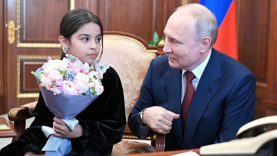 Raisat Akimova, seorang gadis berusia 8 tahun dari Derbent, dan orang tuanya Akhmet dan Kultum Aipovs menghadiri pertemuan dengan Presiden Rusia Vladimir Putin di Kremlin di Moskow, Rusia 4 Juli 2023. Raisat gagal menemui kepala negara selama kunjungannya perjalanan kerja ke Republik Dagestan di mana dia juga berbicara dengan penduduk setempat. (Sputnik/Alexander Kazakov/Kremlin via REUTERS)