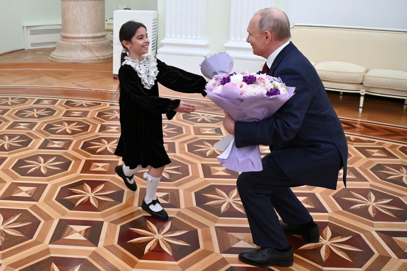 Raisat Akimova, seorang gadis berusia 8 tahun dari Derbent, dan orang tuanya Akhmet dan Kultum Aipovs menghadiri pertemuan dengan Presiden Rusia Vladimir Putin di Kremlin di Moskow, Rusia 4 Juli 2023. Raisat gagal menemui kepala negara selama kunjungannya perjalanan kerja ke Republik Dagestan di mana dia juga berbicara dengan penduduk setempat. (Sputnik/Alexander Kazakov/Kremlin via REUTERS)