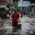 Warga melintas saat terjadi banjir pada pemukiman warga di kawasan Petogogan, Jakarta Selatan, Jumat (7/7/2023). (CNBC Indonesia/Faisal Rahman)