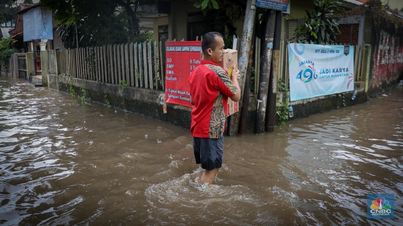 Warga melintas saat terjadi banjir pada pemukiman warga di kawasan Petogogan, Jakarta Selatan, Jumat (7/7/2023). (CNBC Indonesia/Faisal Rahman)