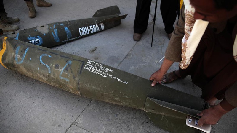 In this Oct. 5, 2016 photo, a Yemeni man displays an American-made CBU 58A/B, cluster bomb, in a police compound in Sanaa, Yemen. In the air campaign by Saudi Arabia and its allies against Yemen’s Shiite rebels, rights experts say there has been a pattern by the Saudi-led coalition in depending on faulty intelligence, failing to distinguish between civilian and military targets and disregarding the likelihood of civilian casualties. Experts say some of the strikes likely amount to war crimes. (AP Photo/Hani Mohammed)