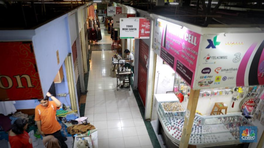 Pengunjung melintas dikawasan disalah satu kios di Pasar Santa, Jakarta, Senin (10/07/2023). Geliat ekonomi di pasar Santa yang dulunya populer di DKI Jakarta belum pulih sepenuhnya, salah satunya di Pasar Senen, Jakarta Pusat. (CNBC Indonesia/Muhammad Sabki)