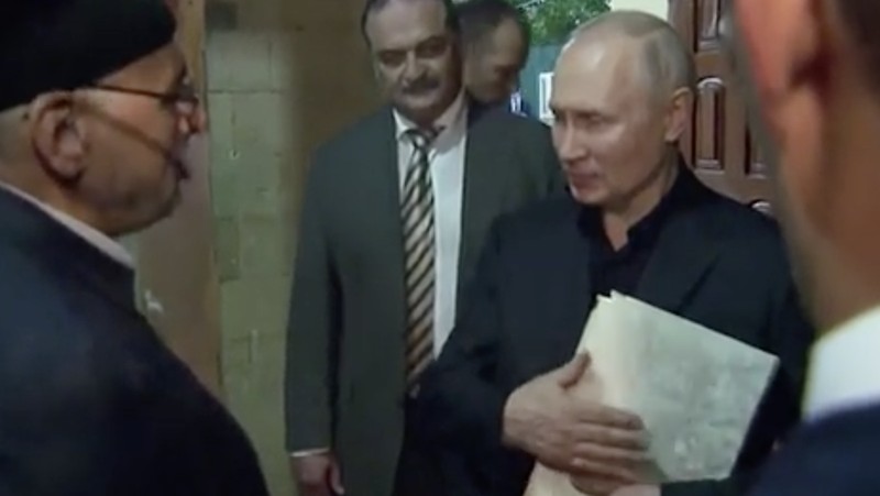 Presiden Rusia, Vladimir Putin pegang Al Qur'an. (Tangakapan Layar/REUTERS)