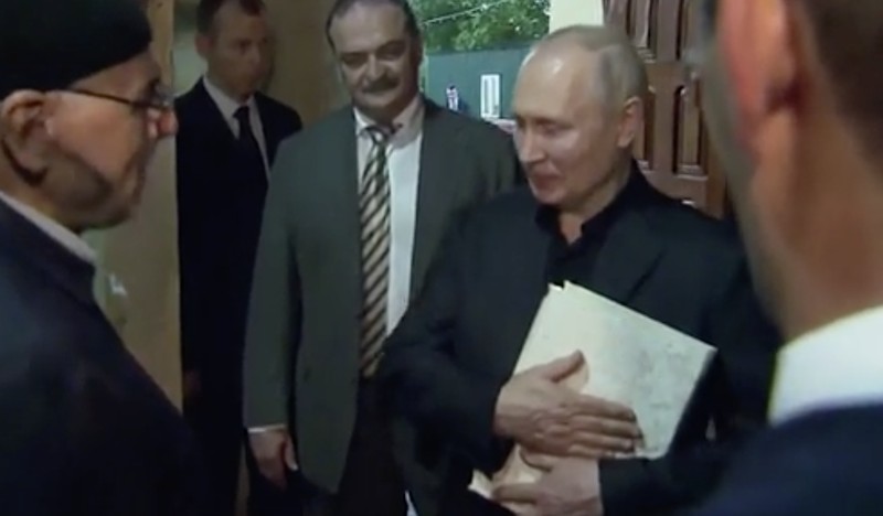 Presiden Rusia, Vladimir Putin pegang Al Qur'an. (Tangakapan Layar/REUTERS) Presiden Rusia, Vladimir Putin pegang Al Qur'an. (Tangakapan Layar/REUTERS)