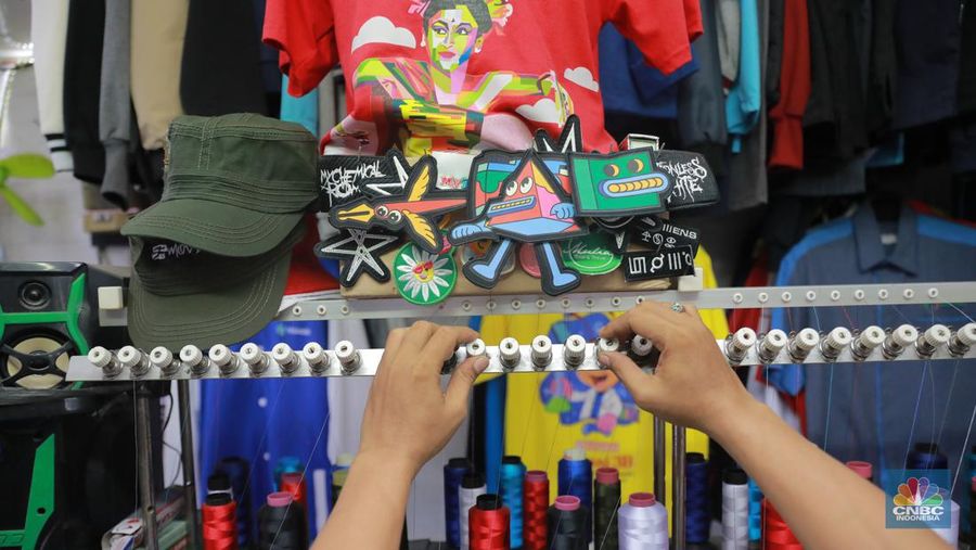 Pekerja menyelesaikan bordir atribut fashion di Kawasan Kebayoran Baru, Jakarta, Selasa (11/7/2023). (CNBC Indonesia/Muhammad Sabki)