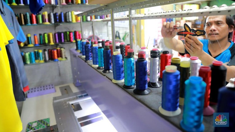 Pekerja menyelesaikan bordir atribut fashion di Kawasan Kebayoran Baru, Jakarta, Selasa (11/7/2023). (CNBC Indonesia/Muhammad Sabki)