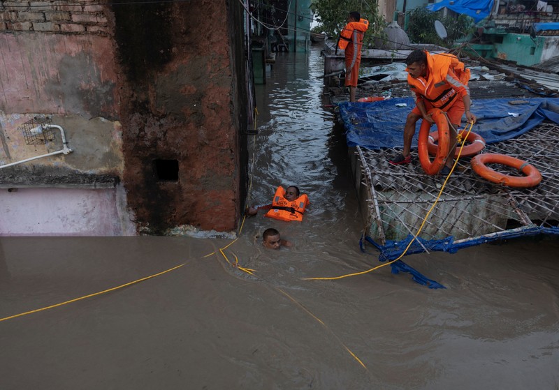 Anggota Pasukan Tanggap Bencana Nasional (NDRF) mengevakuasi penduduk yang terdampar dari lokasi banjir, setelah kenaikan permukaan air sungai Yamuna, di New Delhi, India, 13 Juli 2023. (REUTERS/Adnan Abidi)