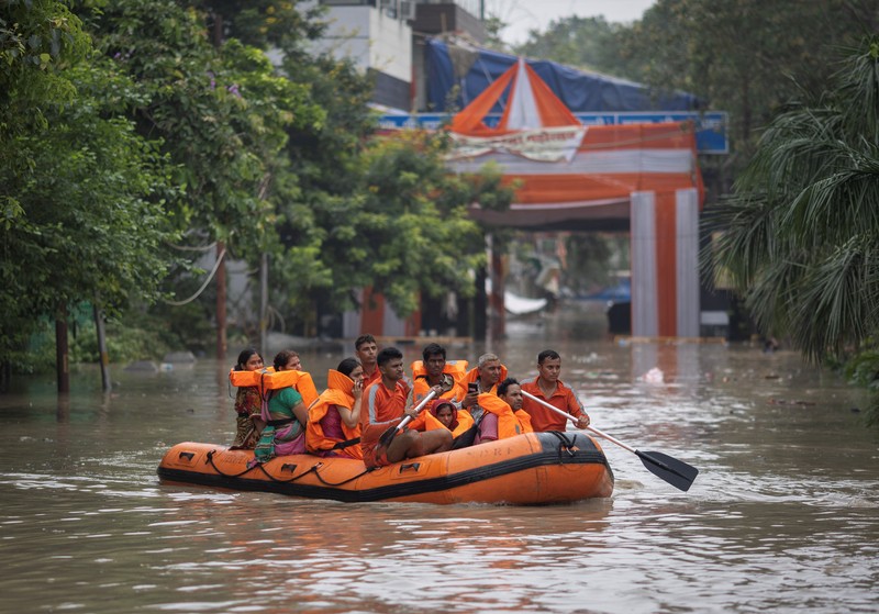 Anggota Pasukan Tanggap Bencana Nasional (NDRF) mengevakuasi penduduk yang terdampar dari lokasi banjir, setelah kenaikan permukaan air sungai Yamuna, di New Delhi, India, 13 Juli 2023. (REUTERS/Adnan Abidi)