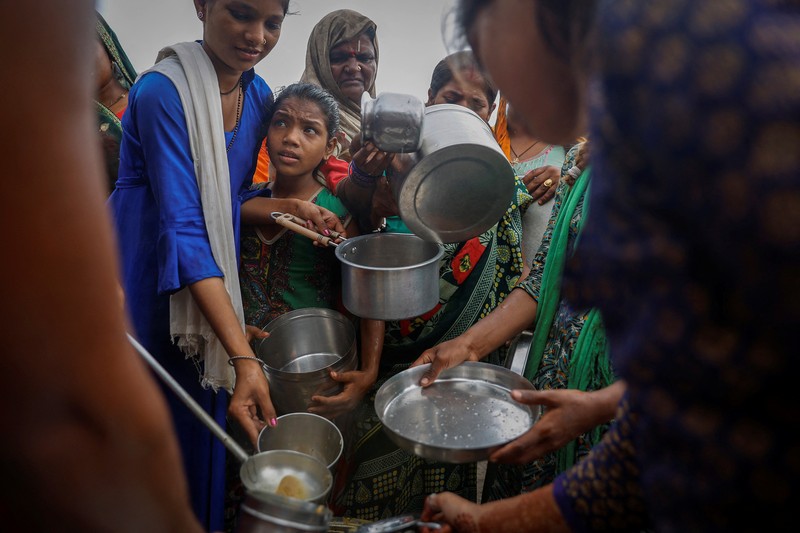 Anggota Pasukan Tanggap Bencana Nasional (NDRF) mengevakuasi penduduk yang terdampar dari lokasi banjir, setelah kenaikan permukaan air sungai Yamuna, di New Delhi, India, 13 Juli 2023. (REUTERS/Adnan Abidi)