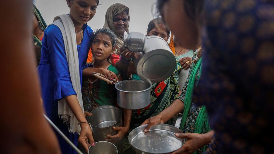 Orang-orang membagikan makanan gratis kepada warga yang mengungsi yang terkena dampak naiknya air sungai Yamuna setelah hujan lebat di New Delhi, India, 12 Juli 2023. (REUTERS/Adnan Abidi)