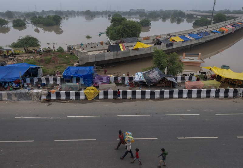 Anggota Pasukan Tanggap Bencana Nasional (NDRF) mengevakuasi penduduk yang terdampar dari lokasi banjir, setelah kenaikan permukaan air sungai Yamuna, di New Delhi, India, 13 Juli 2023. Anggota Pasukan Tanggap Bencana Nasional (NDRF) mengevakuasi penduduk yang terdampar dari lokasi banjir, setelah kenaikan permukaan air sungai Yamuna, di New Delhi, India, 13 Juli 2023. (REUTERS/Adnan Abidi)