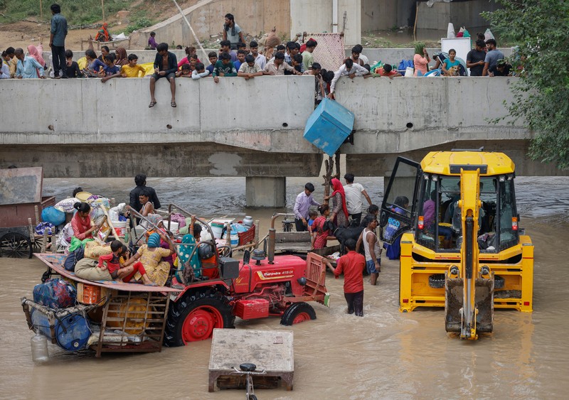 Anggota Pasukan Tanggap Bencana Nasional (NDRF) mengevakuasi penduduk yang terdampar dari lokasi banjir, setelah kenaikan permukaan air sungai Yamuna, di New Delhi, India, 13 Juli 2023. (REUTERS/Adnan Abidi)