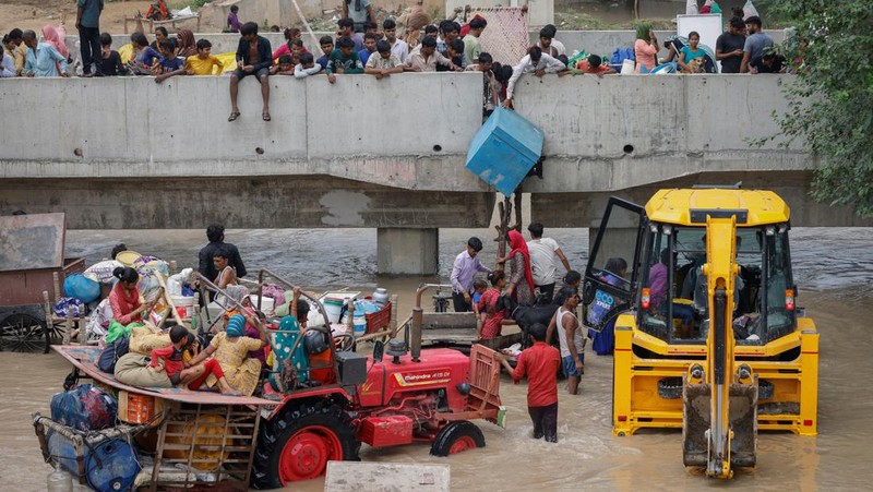 Anggota Pasukan Tanggap Bencana Nasional (NDRF) mengevakuasi penduduk yang terdampar dari lokasi banjir, setelah kenaikan permukaan air sungai Yamuna, di New Delhi, India, 13 Juli 2023. (REUTERS/Adnan Abidi)