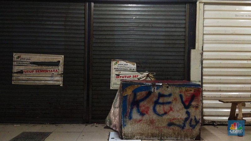Warga beristirahat dengan memanfaatkan ruko yang terbengkalai di Pasar Induk Kramat Jati Blok 1 ACT, Jakarta, Jumat (14/7/2023). (CNBC Indonesia/Tri Susilo)