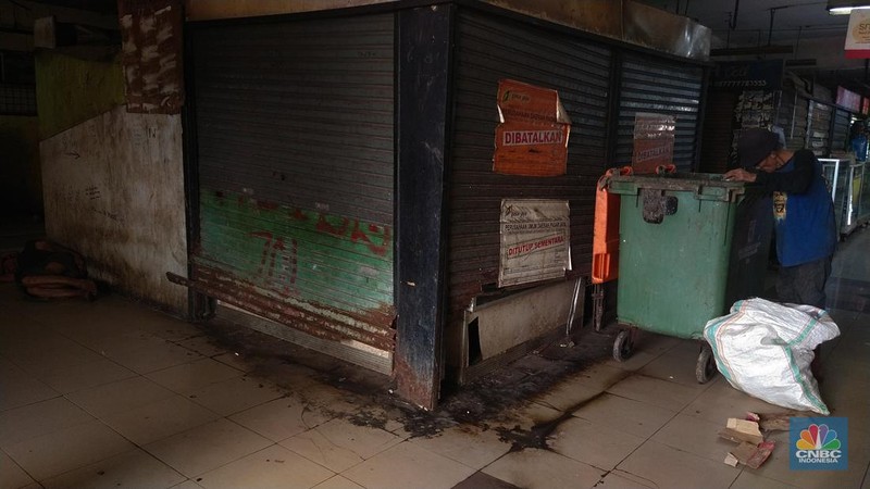 Warga beristirahat dengan memanfaatkan ruko yang terbengkalai di Pasar Induk Kramat Jati Blok 1 ACT, Jakarta, Jumat (14/7/2023). (CNBC Indonesia/Tri Susilo)