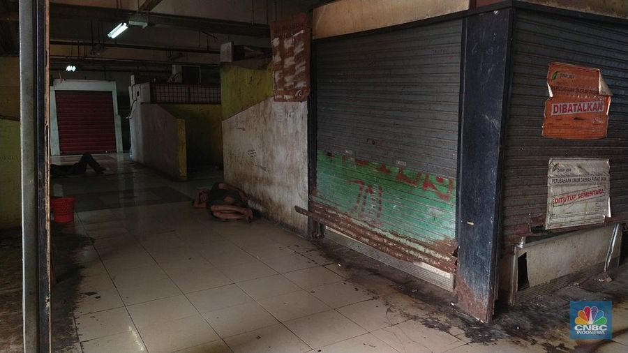 Warga beristirahat dengan memanfaatkan ruko yang terbengkalai di Pasar Induk Kramat Jati Blok 1 ACT, Jakarta, Jumat (14/7/2023). (CNBC Indonesia/Tri Susilo)