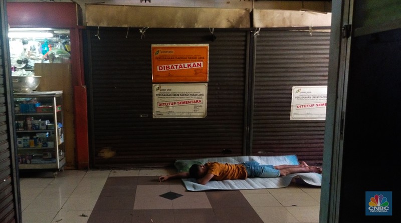 Warga beristirahat dengan memanfaatkan ruko yang terbengkalai di Pasar Induk Kramat Jati Blok 1 ACT, Jakarta, Jumat (14/7/2023). (CNBC Indonesia/Tri Susilo)