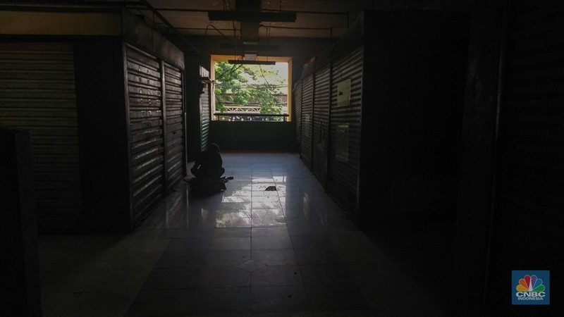 Warga beristirahat dengan memanfaatkan ruko yang terbengkalai di Pasar Induk Kramat Jati Blok 1 ACT, Jakarta, Jumat (14/7/2023). (CNBC Indonesia/Tri Susilo)