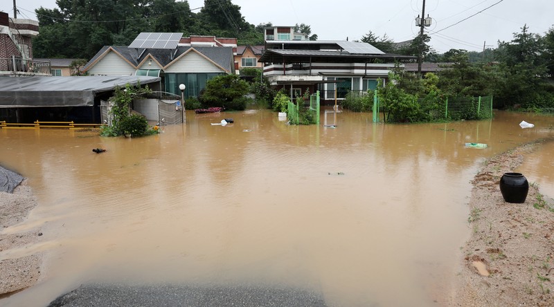 A view of a road submerged by a flooded river caused by heavy rain in Cheongju, South Korea, July 15, 2023.   Yonhap/via REUTERS       ATTENTION EDITORS - THIS IMAGE HAS BEEN SUPPLIED BY A THIRD PARTY. NO RESALES. NO ARCHIVE. SOUTH KOREA OUT. NO COMMERCIAL OR EDITORIAL SALES IN SOUTH KOREA. IMAGE BLURED AT SOURCE.