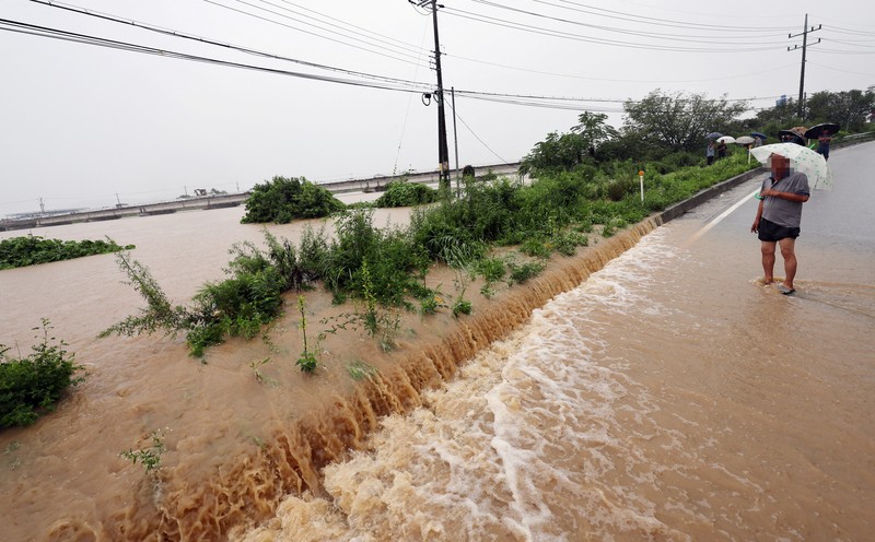 ASIA-WEATHER/SOUTHKOREA A view of a road submerged by a flooded river caused by heavy rain in Cheongju, South Korea, July 15, 2023. Yonhap/via REUTERS ATTENTION EDITORS - THIS IMAGE HAS BEEN SUPPLIED BY A THIRD PARTY. NO RESALES. NO ARCHIVE. SOUTH KOREA OUT. NO COMMERCIAL OR EDITORIAL SALES IN SOUTH KOREA. IMAGE BLURED AT SOURCE.