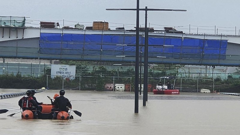 Tim penyelamat melakukan operasi pencarian di sepanjang jalan yang terendam banjir menuju terowongan bawah tanah di Cheongju, Korea Selatan, Minggu, 16 Juli 2023. Hujan deras berhari-hari memicu banjir bandang dan tanah longsor serta menghancurkan rumah, menyebabkan puluhan orang tewas dan memaksa ribuan orang untuk mengungsi, kata para pejabat, Minggu. (Kim Ju-hyung/Yonhap via AP)