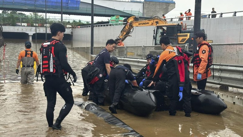 Tim penyelamat melakukan operasi pencarian di sepanjang jalan yang terendam banjir menuju terowongan bawah tanah di Cheongju, Korea Selatan, Minggu, 16 Juli 2023. Hujan deras berhari-hari memicu banjir bandang dan tanah longsor serta menghancurkan rumah, menyebabkan puluhan orang tewas dan memaksa ribuan orang untuk mengungsi, kata para pejabat, Minggu. (Kim Ju-hyung/Yonhap via AP)