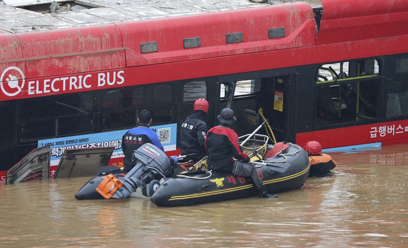 Tim penyelamat melakukan operasi pencarian di sepanjang jalan yang terendam banjir menuju terowongan bawah tanah di Cheongju, Korea Selatan, Minggu, 16 Juli 2023. Hujan deras berhari-hari memicu banjir bandang dan tanah longsor serta menghancurkan rumah, menyebabkan puluhan orang tewas dan memaksa ribuan orang untuk mengungsi, kata para pejabat, Minggu. (Kim Ju-hyung/Yonhap via AP)