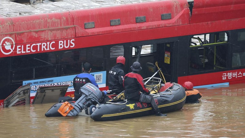Tim penyelamat melakukan operasi pencarian di sepanjang jalan yang terendam banjir menuju terowongan bawah tanah di Cheongju, Korea Selatan, Minggu, 16 Juli 2023. Hujan deras berhari-hari memicu banjir bandang dan tanah longsor serta menghancurkan rumah, menyebabkan puluhan orang tewas dan memaksa ribuan orang untuk mengungsi, kata para pejabat, Minggu. (Kim Ju-hyung/Yonhap via AP)