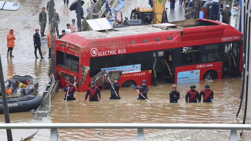 Tim penyelamat melakukan operasi pencarian di sepanjang jalan yang terendam banjir menuju terowongan bawah tanah di Cheongju, Korea Selatan, Minggu, 16 Juli 2023. Hujan deras berhari-hari memicu banjir bandang dan tanah longsor serta menghancurkan rumah, menyebabkan puluhan orang tewas dan memaksa ribuan orang untuk mengungsi, kata para pejabat, Minggu. (Kim Ju-hyung/Yonhap via AP)