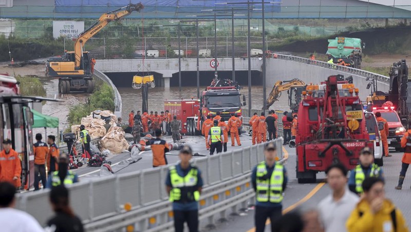 Tim penyelamat melakukan operasi pencarian di sepanjang jalan yang terendam banjir menuju terowongan bawah tanah di Cheongju, Korea Selatan, Minggu, 16 Juli 2023. Hujan deras berhari-hari memicu banjir bandang dan tanah longsor serta menghancurkan rumah, menyebabkan puluhan orang tewas dan memaksa ribuan orang untuk mengungsi, kata para pejabat, Minggu. (Kim Ju-hyung/Yonhap via AP)