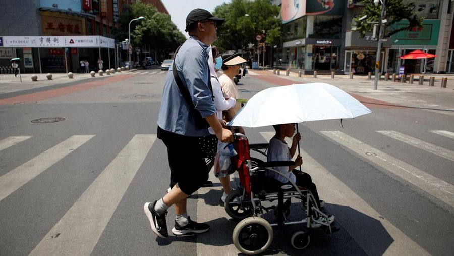 Pejalan kaki menyeberang jalan saat cuaca panas di tengah peringatan oranye untuk gelombang panas, di Beijing, China 16 Juni 2023. REUTERS/Florence Lo/File Foto