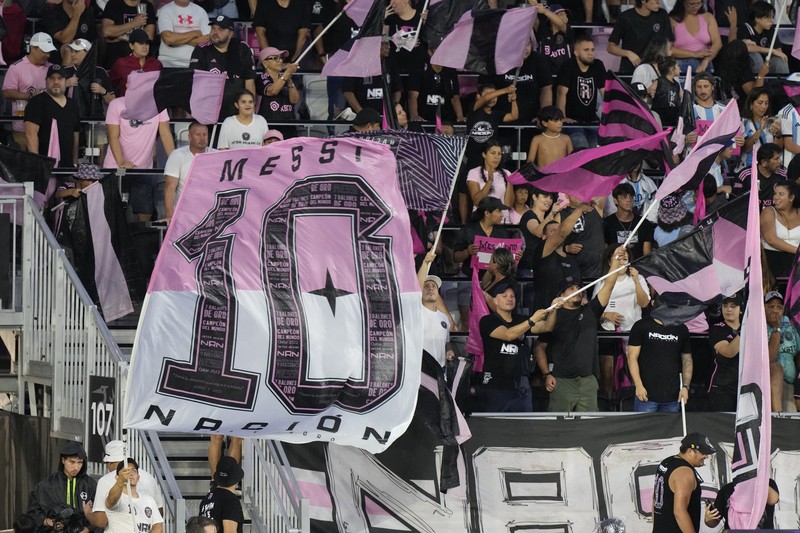 Lionel Messi dari Inter Miami, kiri tengah, memegang jersey tim barunya saat ia berpose dengan rekan pemilik tim Jorge Mas, kiri, Jose Mas, kanan kedua, dan David Beckham, kanan, saat ia diperkenalkan saat perayaan oleh tim di DRV Stadion PNK, Minggu, 16 Juli 2023, di Fort Lauderdale, Florida. (AP Photo/Rebecca Blackwell)