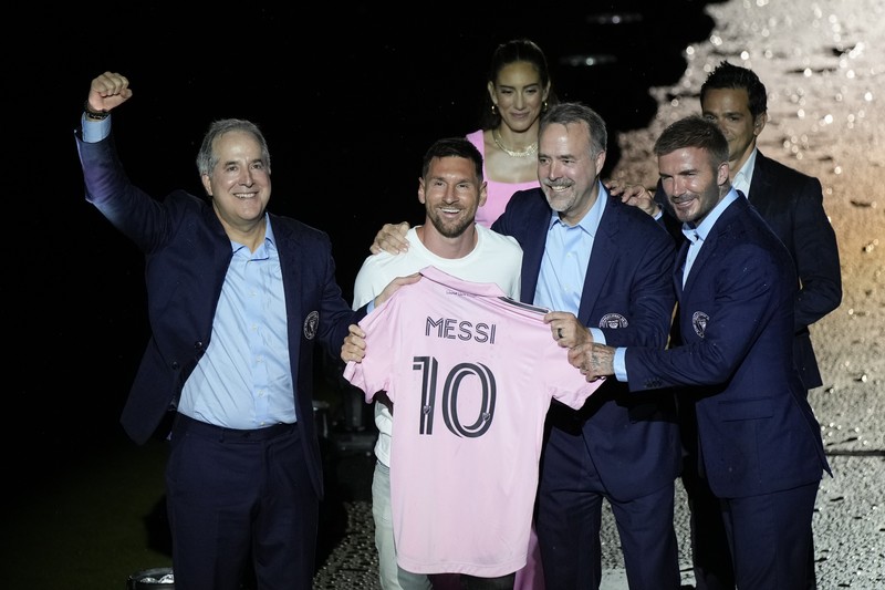 Lionel Messi dari Inter Miami, kiri tengah, memegang jersey tim barunya saat ia berpose dengan rekan pemilik tim Jorge Mas, kiri, Jose Mas, kanan kedua, dan David Beckham, kanan, saat ia diperkenalkan saat perayaan oleh tim di DRV Stadion PNK, Minggu, 16 Juli 2023, di Fort Lauderdale, Florida. (AP Photo/Rebecca Blackwell)