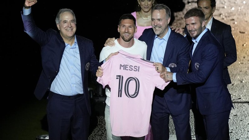 Lionel Messi dari Inter Miami, kiri tengah, memegang jersey tim barunya saat ia berpose dengan rekan pemilik tim Jorge Mas, kiri, Jose Mas, kanan kedua, dan David Beckham, kanan, saat ia diperkenalkan saat perayaan oleh tim di DRV Stadion PNK, Minggu, 16 Juli 2023, di Fort Lauderdale, Florida. (AP Photo/Rebecca Blackwell)