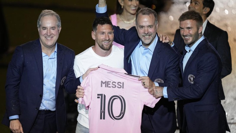 Lionel Messi dari Inter Miami, kiri tengah, memegang jersey tim barunya saat ia berpose dengan rekan pemilik tim Jorge Mas, kiri, Jose Mas, kanan kedua, dan David Beckham, kanan, saat ia diperkenalkan saat perayaan oleh tim di DRV Stadion PNK, Minggu, 16 Juli 2023, di Fort Lauderdale, Florida. (AP Photo/Rebecca Blackwell)