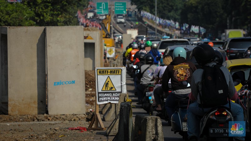 Pengendara melintas di dekat proyek pembangunan saluran air atau drainase di Jalan KH Abdullah Syafei, Jakarta, Senin (17/7/2023). Pengendara melintas di dekat proyek pembangunan saluran air atau drainase di Jalan KH Abdullah Syafei, Jakarta, Senin (17/7/2023). (CNBC Indonesia/Faisal Rahman)