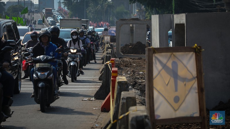 Pengendara melintas di dekat proyek pembangunan saluran air atau drainase di Jalan KH Abdullah Syafei, Jakarta, Senin (17/7/2023). Pengendara melintas di dekat proyek pembangunan saluran air atau drainase di Jalan KH Abdullah Syafei, Jakarta, Senin (17/7/2023). (CNBC Indonesia/Faisal Rahman)