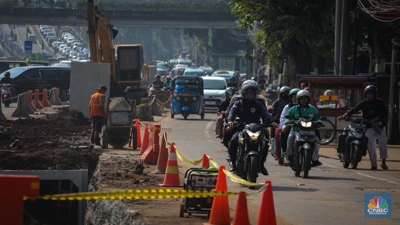 Pengendara melintas di dekat proyek pembangunan saluran air atau drainase di Jalan KH Abdullah Syafei, Jakarta, Senin (17/7/2023). Pengendara melintas di dekat proyek pembangunan saluran air atau drainase di Jalan KH Abdullah Syafei, Jakarta, Senin (17/7/2023). (CNBC Indonesia/Faisal Rahman)