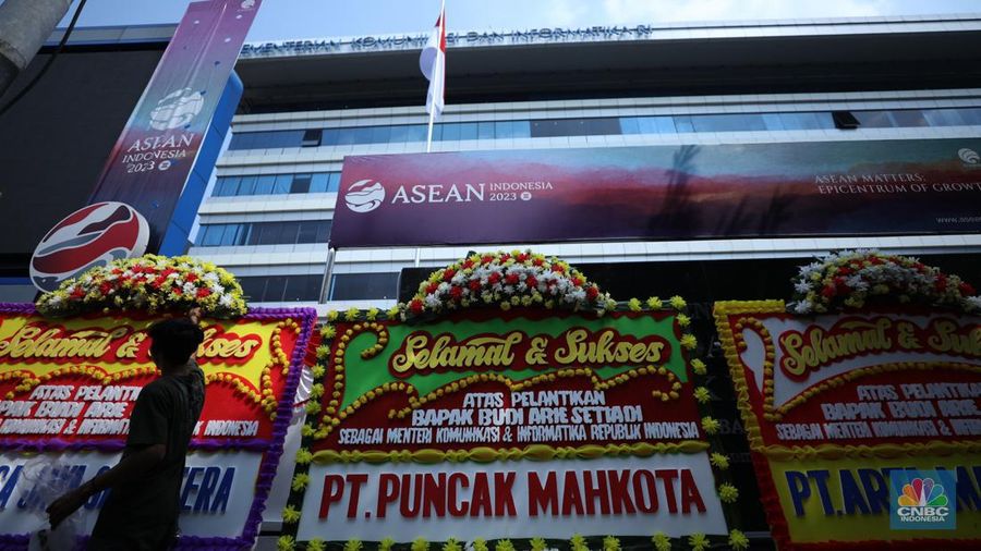 Petugas memasang karangan bunga di halaman kantor Kementerian Komunikasi dan Informatika (Kominfo) Jakarta, Senin (17/7/2023). (CNBC Indonesia/Tri Susilo)