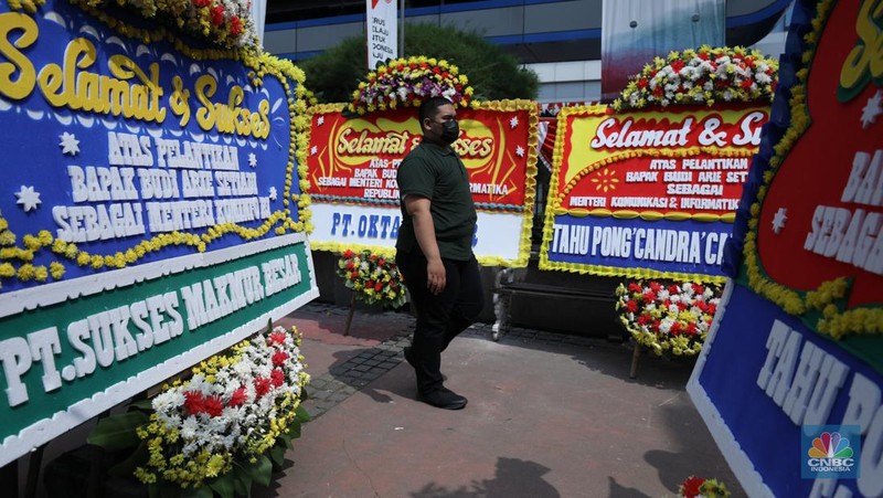 Petugas memasang karangan bunga di halaman kantor Kementerian Komunikasi dan Informatika (Kominfo) Jakarta, Senin (17/7/2023). (CNBC Indonesia/Tri Susilo)