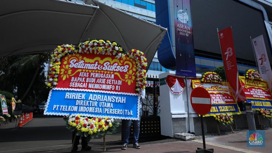 Petugas memasang karangan bunga di halaman kantor Kementerian Komunikasi dan Informatika (Kominfo) Jakarta, Senin (17/7/2023). (CNBC Indonesia/Tri Susilo)