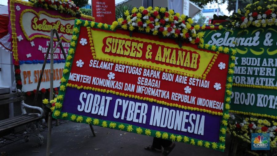 Petugas memasang karangan bunga di halaman kantor Kementerian Komunikasi dan Informatika (Kominfo) Jakarta, Senin (17/7/2023). (CNBC Indonesia/Tri Susilo)