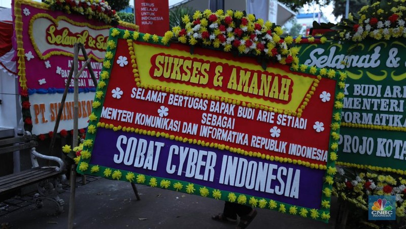 Petugas memasang karangan bunga di halaman kantor Kementerian Komunikasi dan Informatika (Kominfo) Jakarta, Senin (17/7/2023). (CNBC Indonesia/Tri Susilo)